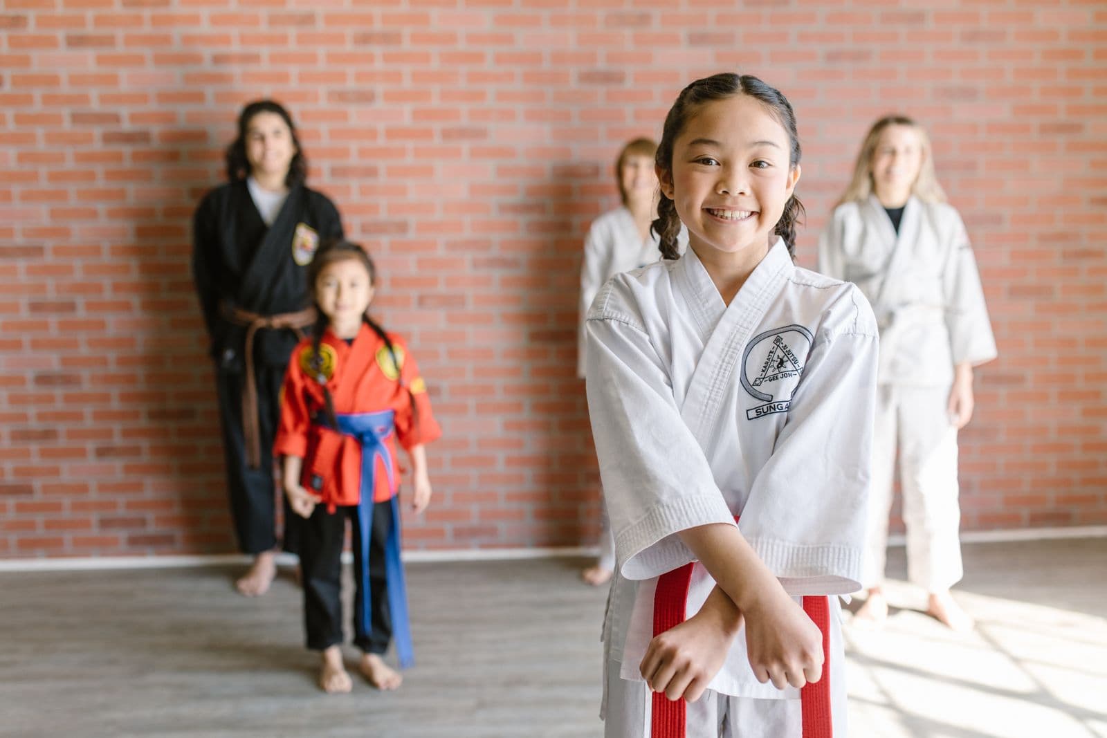 Young karate students practicing with their instructor in a dojo
